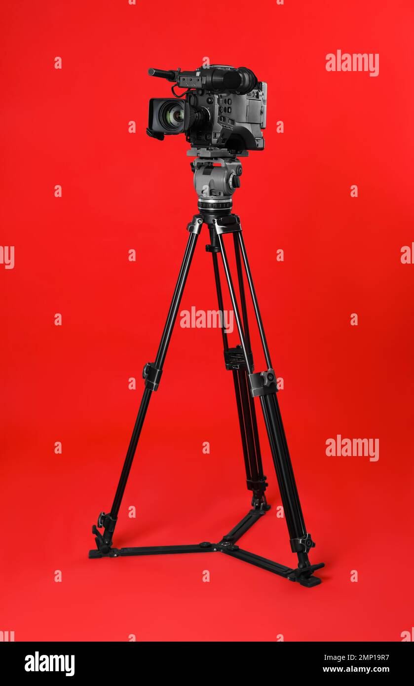 Modern professional video camera on red background Stock Photo - Alamy