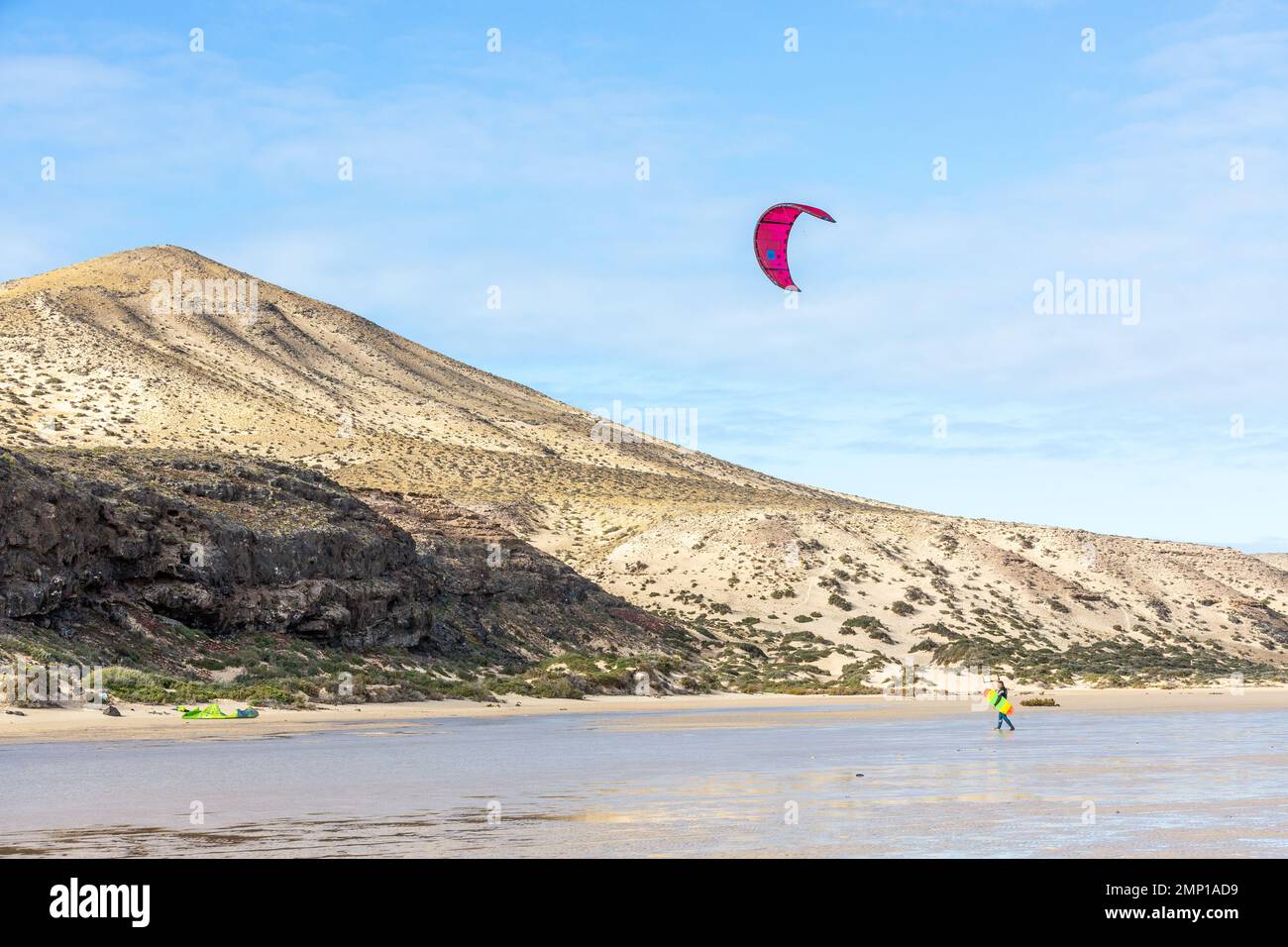 Kitesurfer reaching the beach. Barren hill in the background. Sotavento Beach, Fuerteventura, Canary Islands. Stock Photo