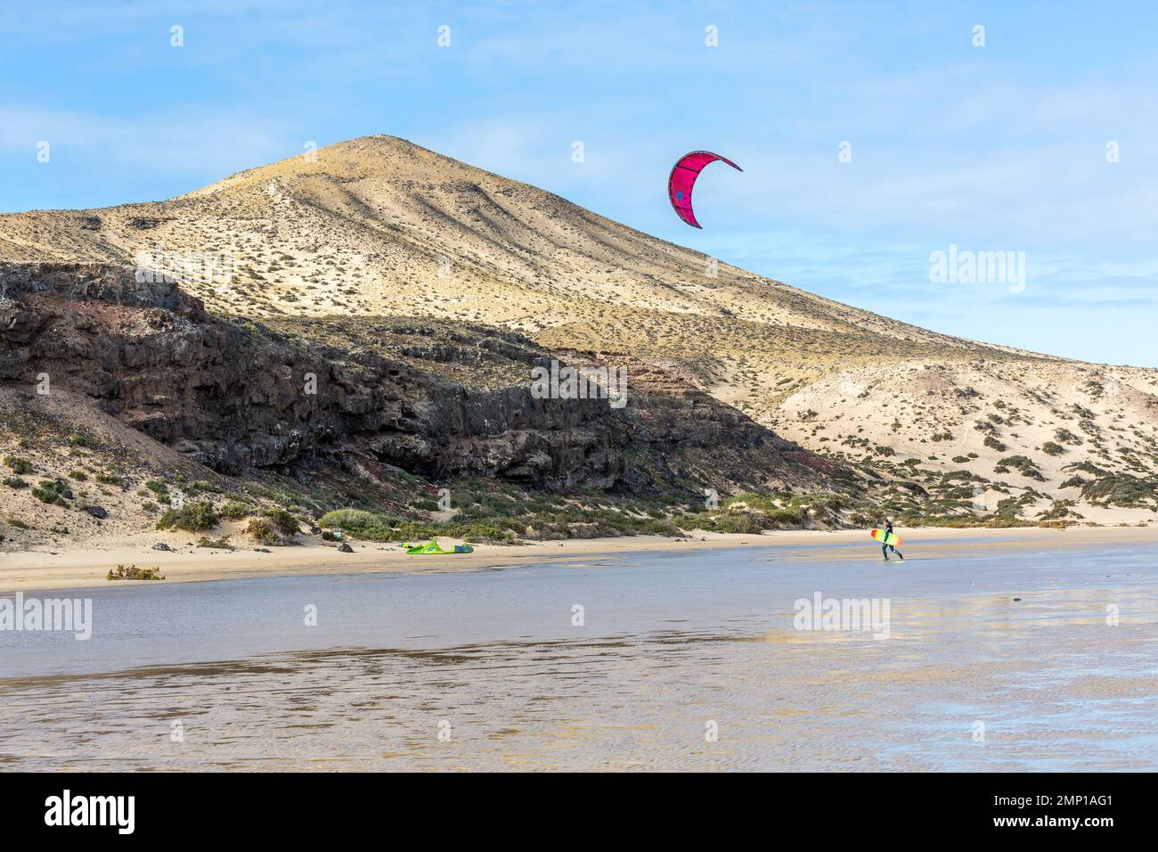 Kitesurfer reaching the beach. Barren hill in the background. Sotavento Beach, Fuerteventura, Canary Islands. Stock Photo