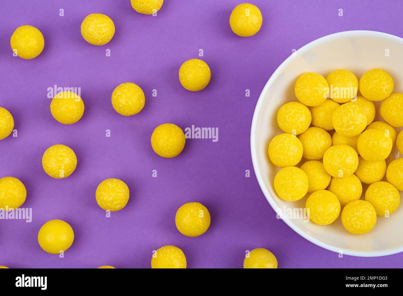 Delicious lemon chewing gums on purple background, flat lay Stock Photo