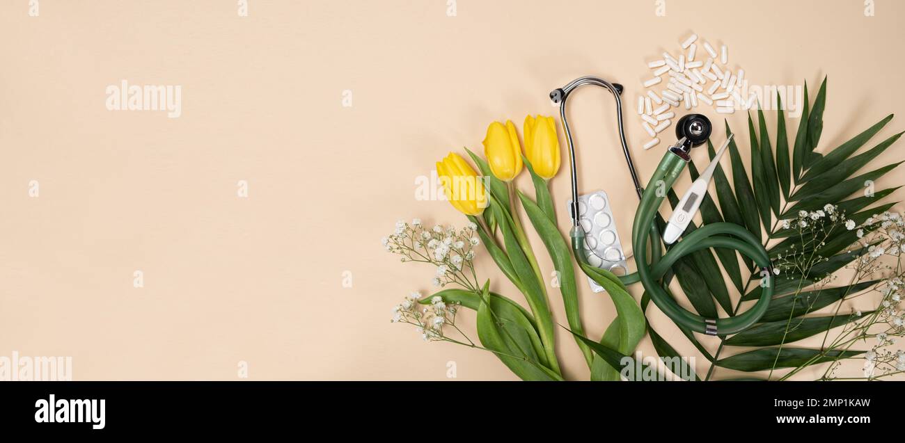 Bouquet of flowers and stethoscope on a beige background, a place for text, happy doctors day, nurses week and other medical holidays. Stock Photo