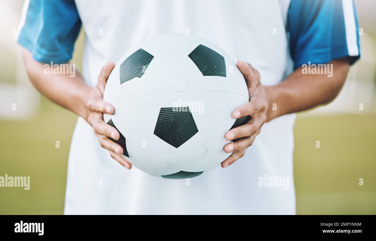 Hands, ball and soccer player ready for sports match, game or competition on the outdoor field. Hand holding round sphere object for sport, training Stock Photo