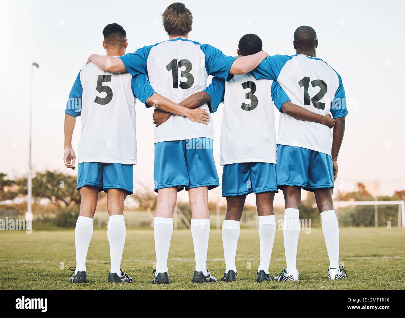 Soccer, team and hug standing with back on the field in partnership, trust or ready for sports game or match. Sport men hugging in teamwork Stock Photo