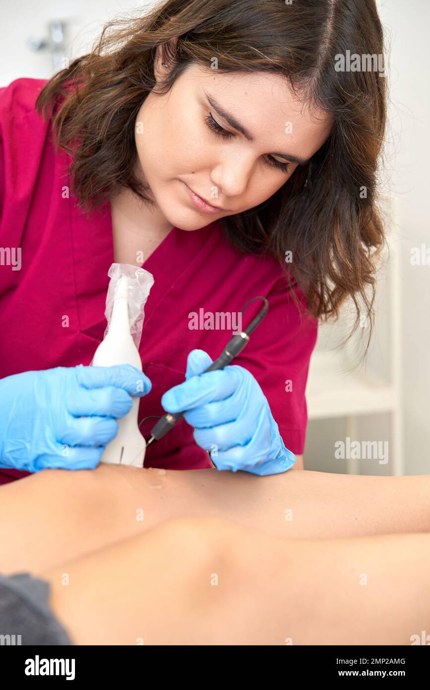 Therapist performing a percutaneous electrolysis procedure with