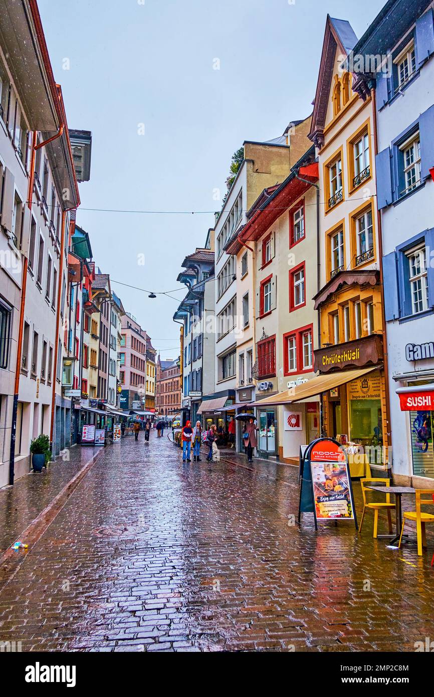 BASEL, SWITZERLAND - APRIL 1, 2022: Gerbergasse shopping street with numerous shops and boutiques on the ground floors of historical houses, on April Stock Photo