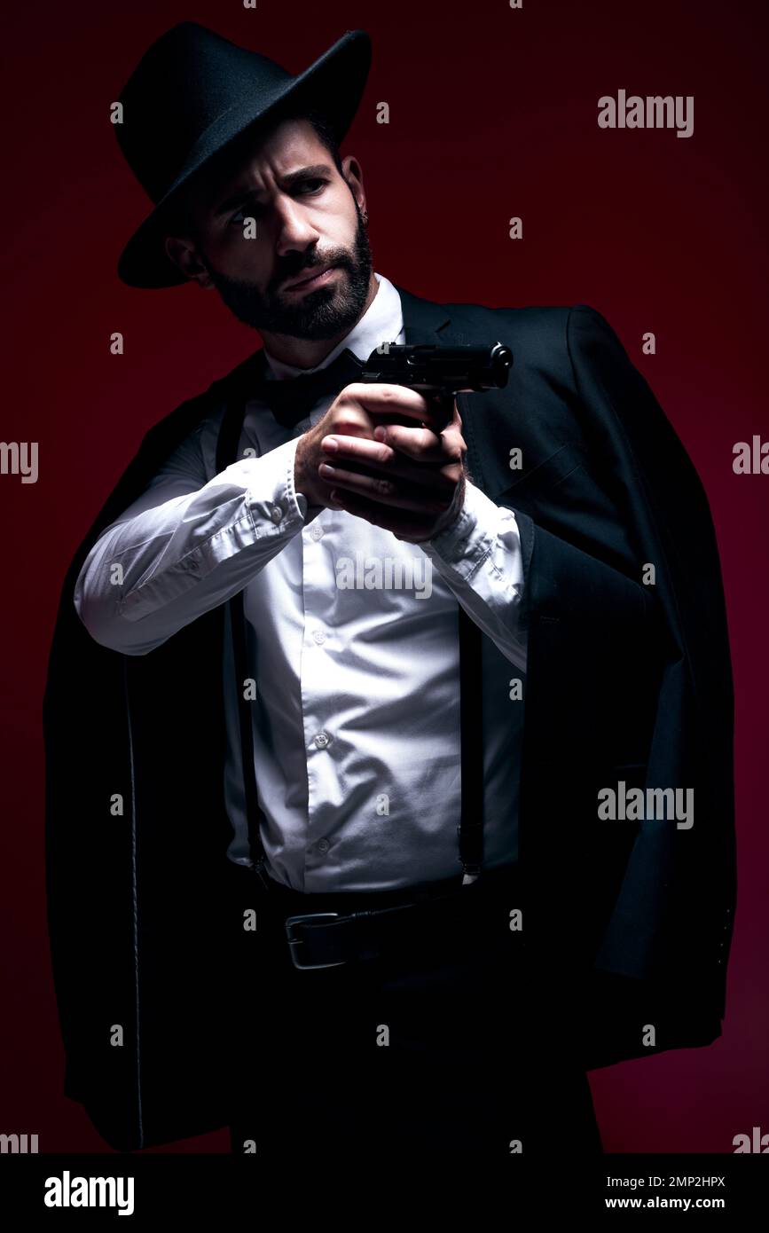 Assassin, suit or shooting gun on studio background in dark secret spy, isolated mafia leadership or crime security. Model, gangster or hitman weapon Stock Photo