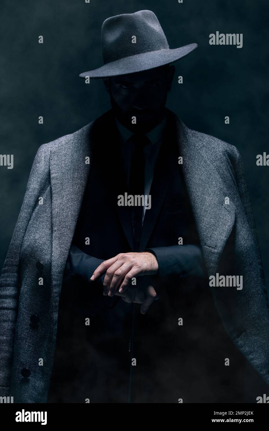 Mafia, fashion and mystery man in a suit isolated on a dark background in a studio. Business, vintage and stylish secret businessman for crime Stock Photo