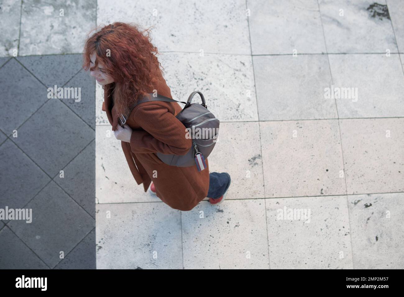 Woman seen from above walking on the sidewalk Stock Photo