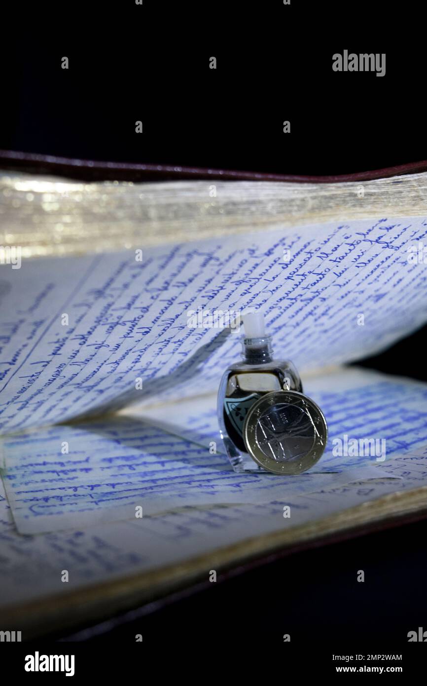 old handwritten paper diary with bottle of ink and an euro coin Stock Photo