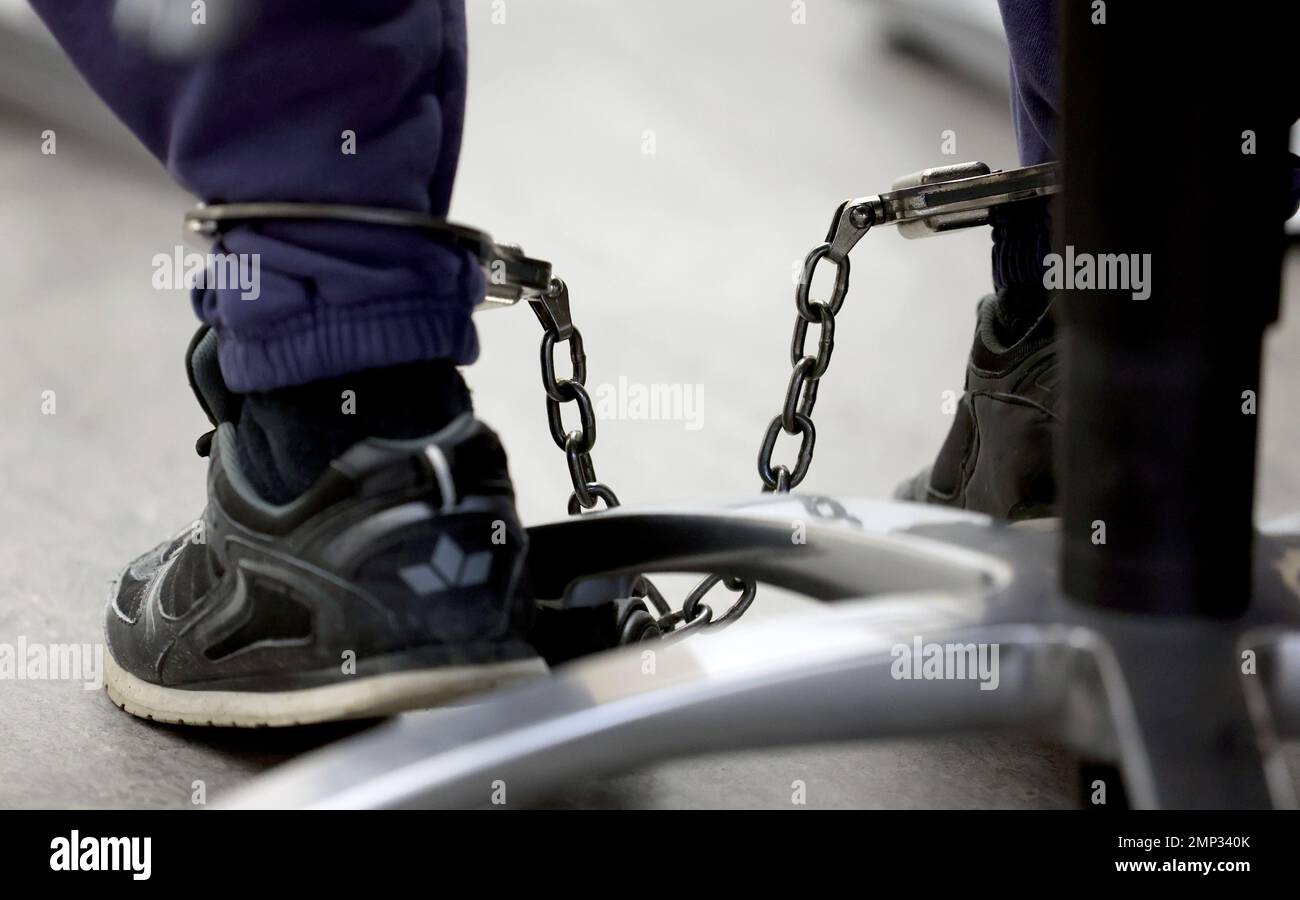 Rostock, Germany. 31st Jan, 2023. The defendant in the triple murder trial waits in the courtroom with an ankle bracelet for the trial to continue. The 27-year-old man allegedly killed his parents and sister in Rövershagen last February. Credit: Bernd Wüstneck/dpa/Alamy Live News Stock Photo