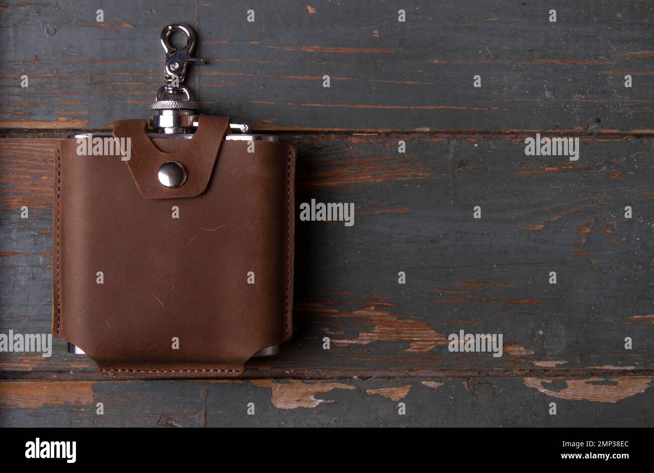 Hip flask in leather Hip flask cover on wooden background. Banner with copy space for text place Stock Photo