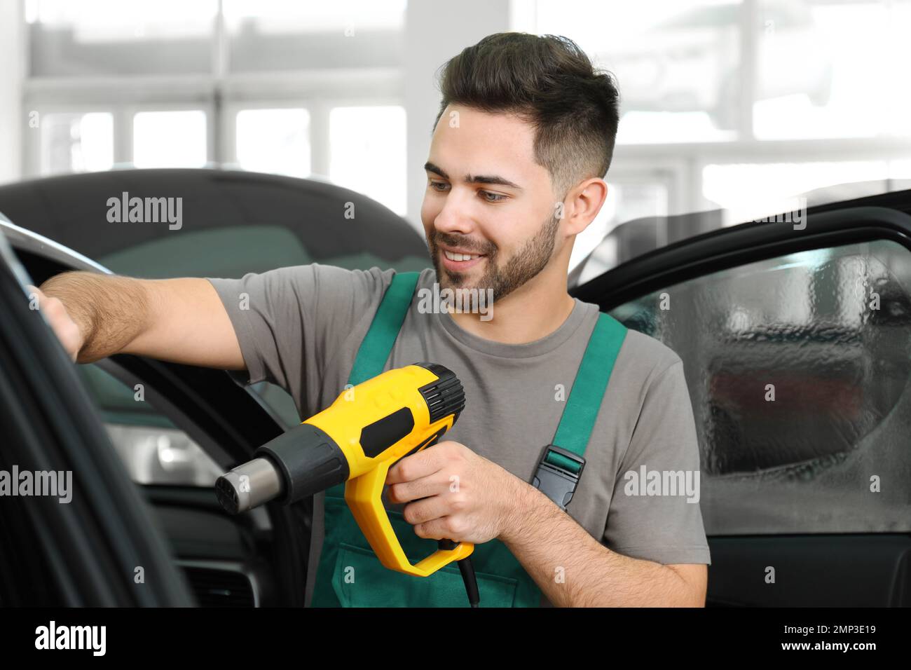 Worker tinting car window with heat gun in Stock Photo Alamy