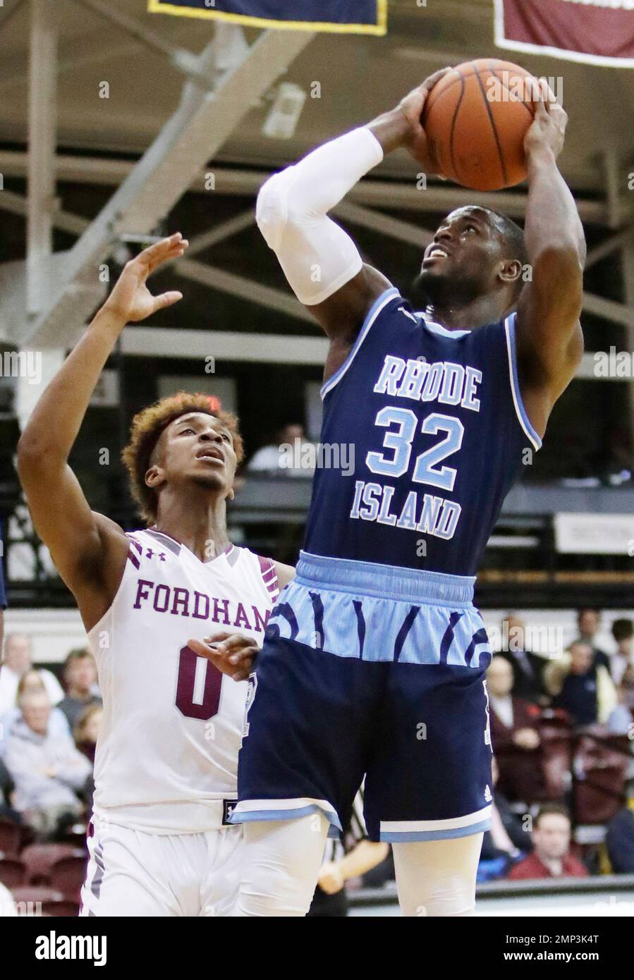 Rhode Island's Jared Terrell (32) drives past Fordham's Will Tavares (0