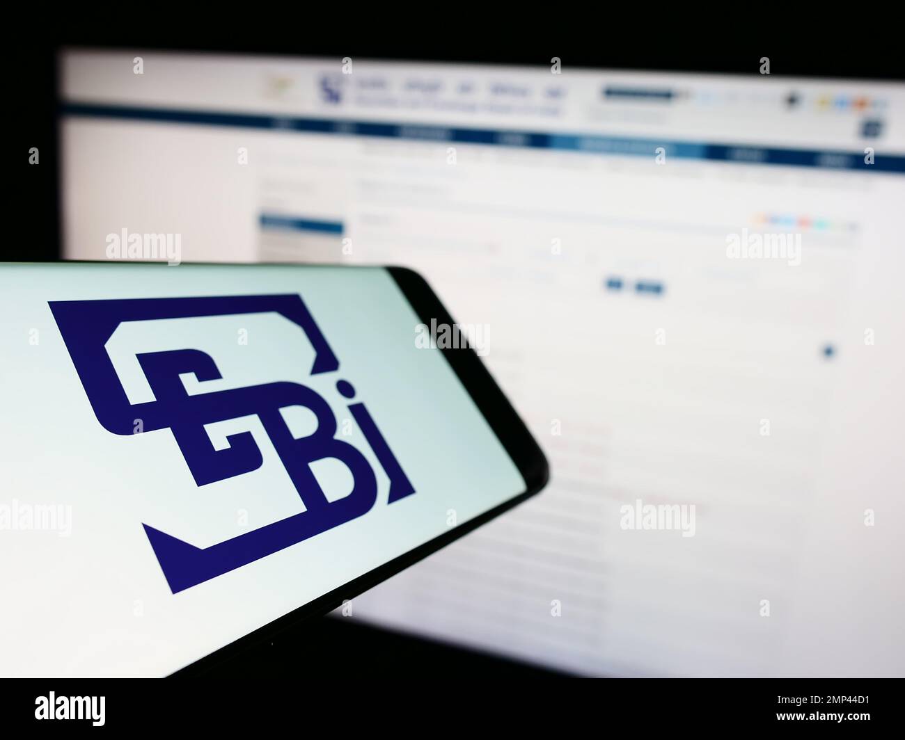 Smartphone with logo of Securities and Exchange Board of India (SEBI) on screen in front of website. Focus on left of phone display. Stock Photo