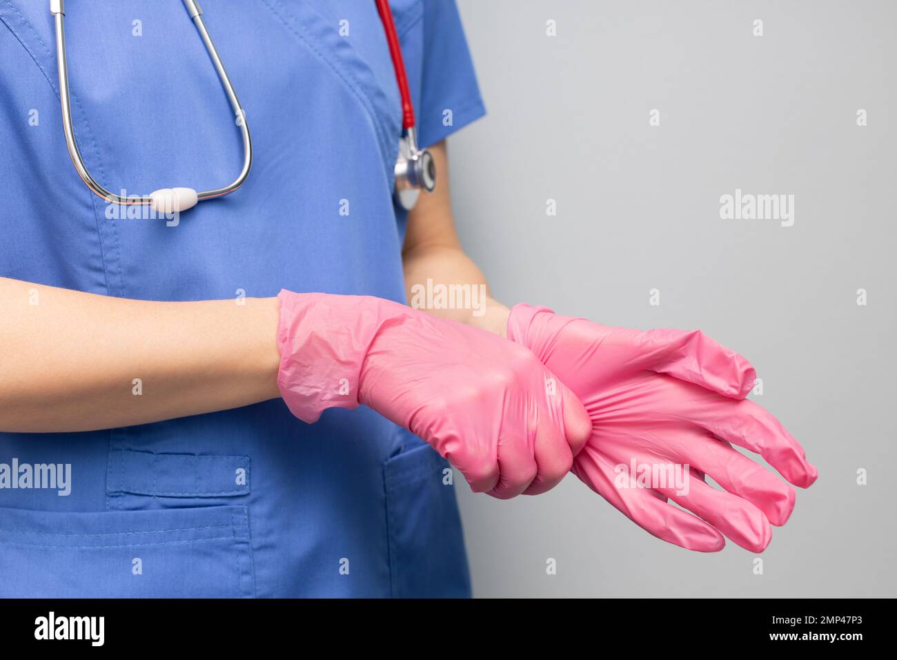 doctor in the hospital puts on a glove. doctor wear gloves. doctor puts on rubber gloves. doctor getting ready for work Stock Photo
