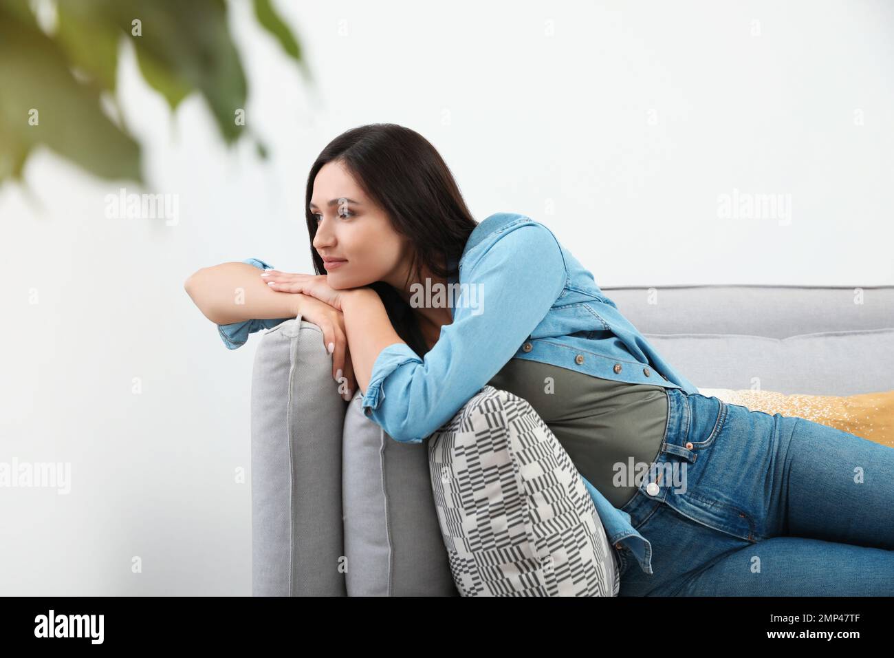 Young woman relaxing on couch at home Stock Photo