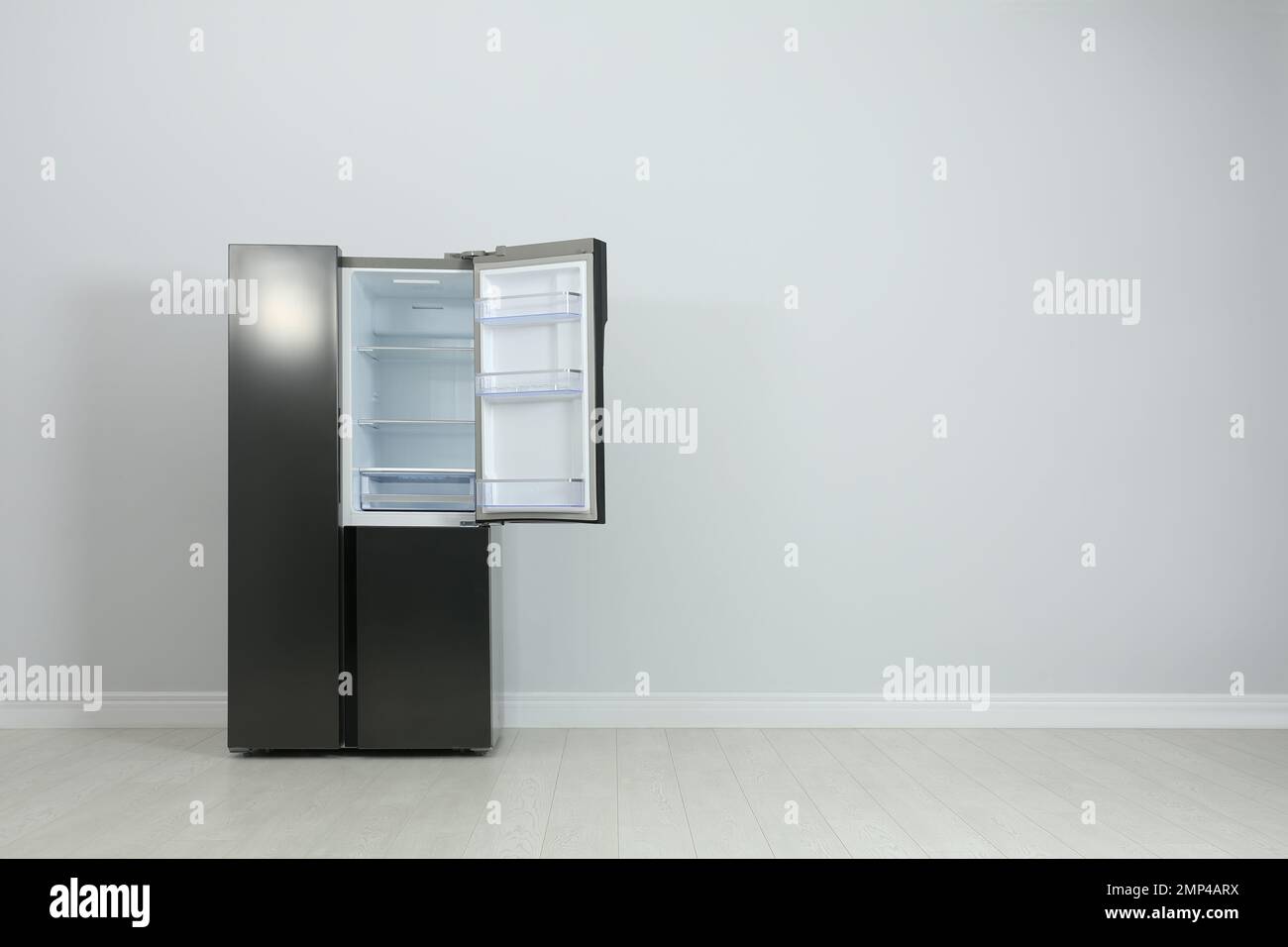 Modern refrigerator near light grey wall. space for text Stock Photo