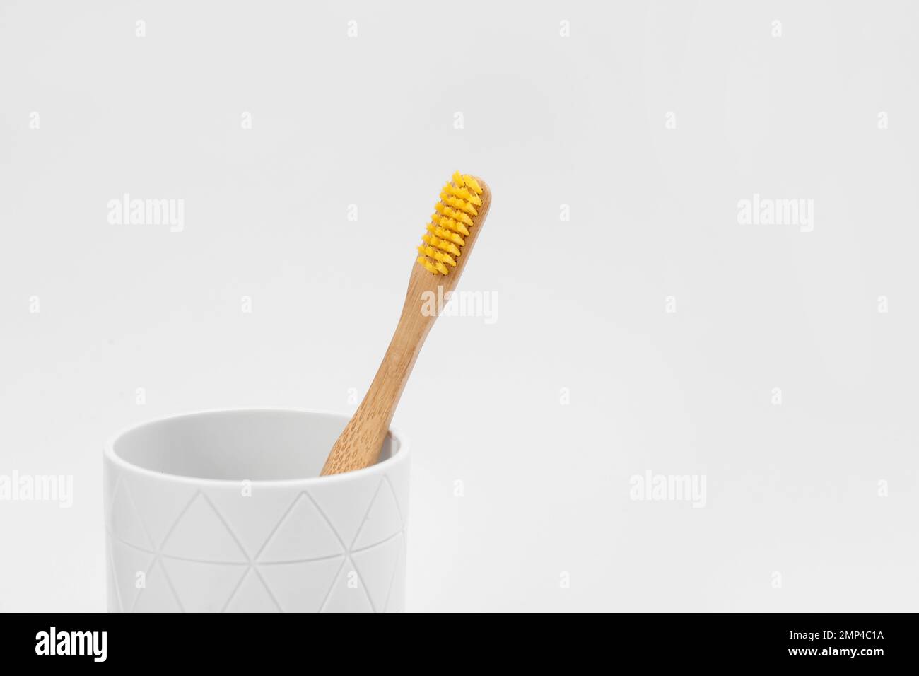 Bamboo toothbrush in holder isolated on white Stock Photo - Alamy