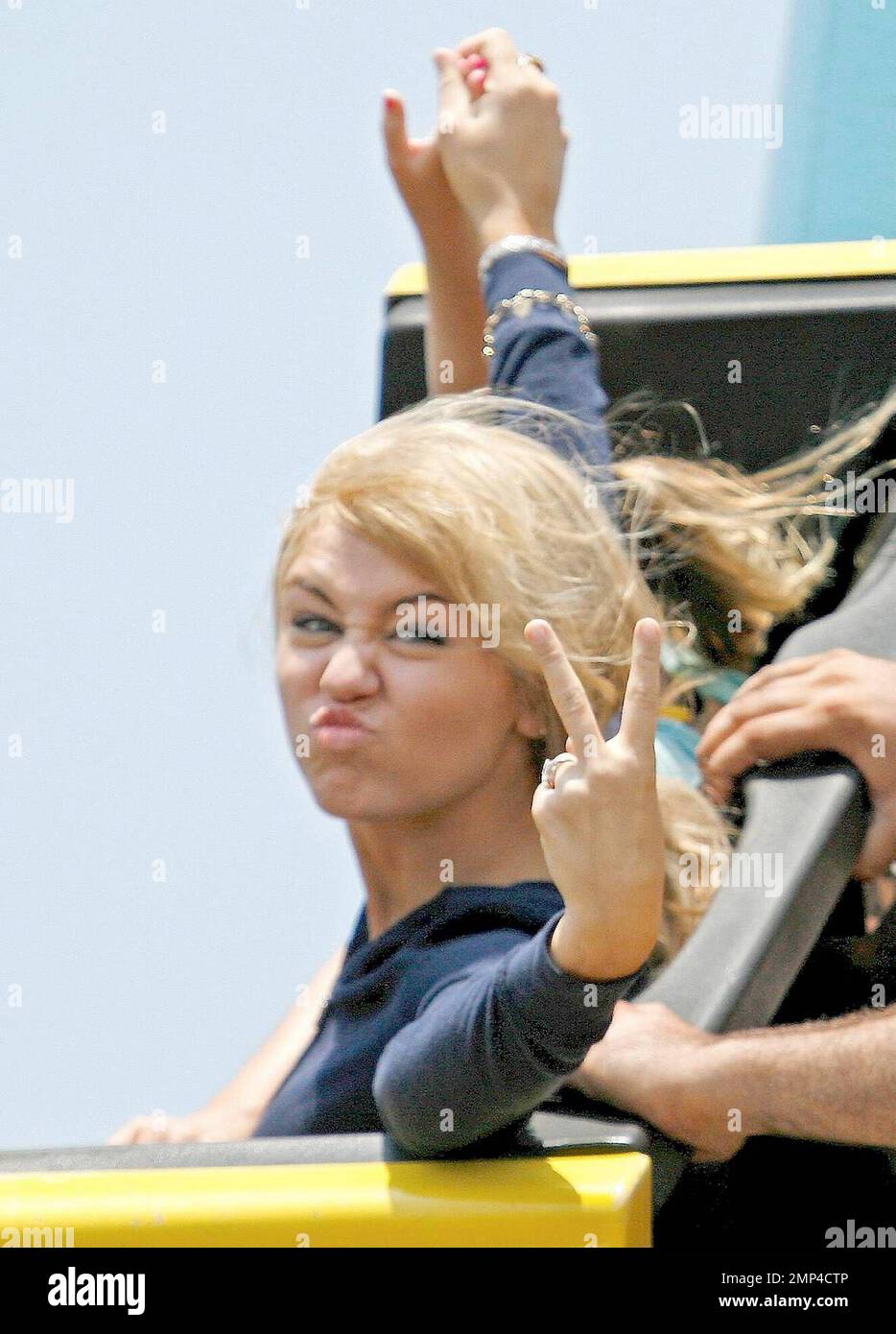 Miley Cyrus has fun on the rides with her sister (check) at the Santa