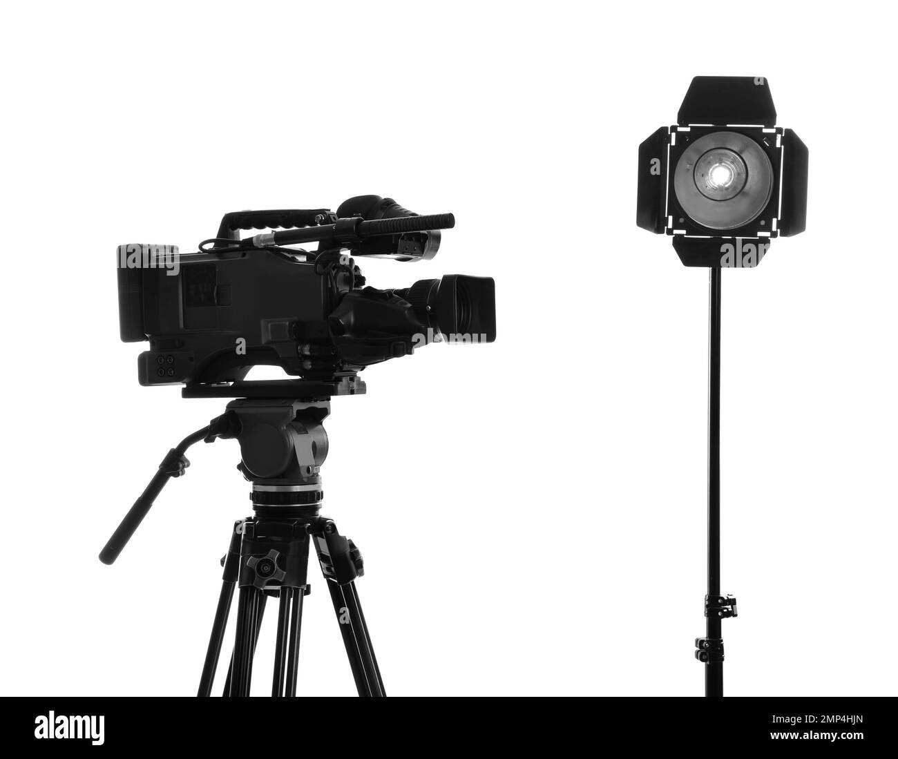 Professional video camera and lighting equipment isolated on white