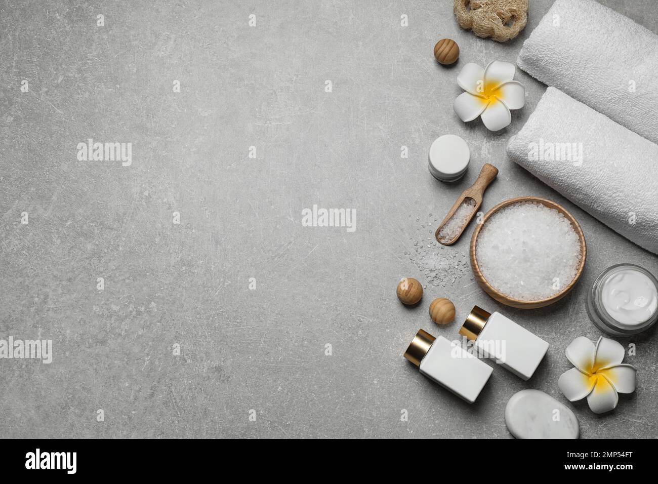Flat lay composition with cosmetics and sea salt on grey marble table ...