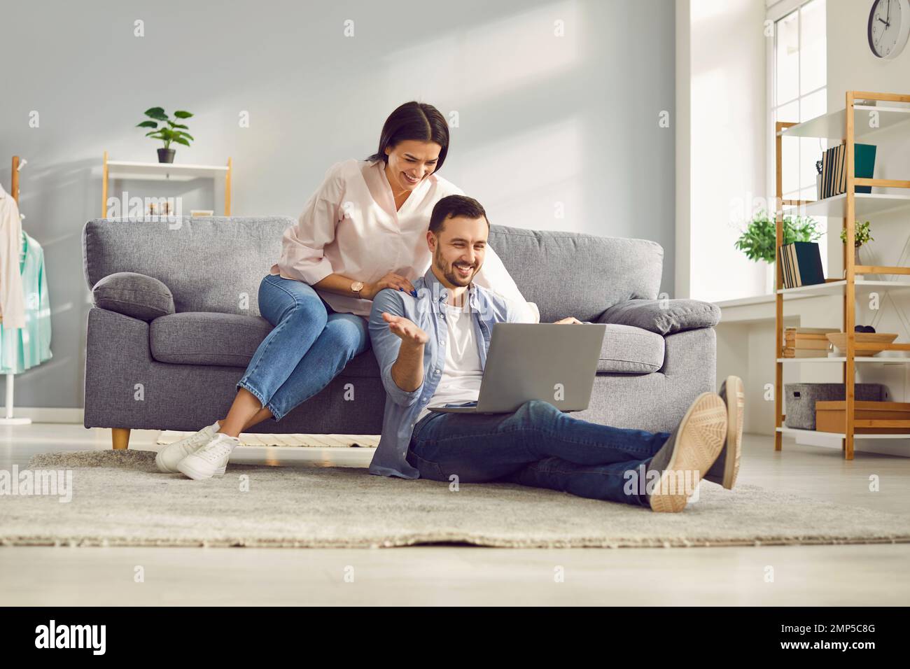 Happy couple having video chat using laptop computer at home Stock Photo