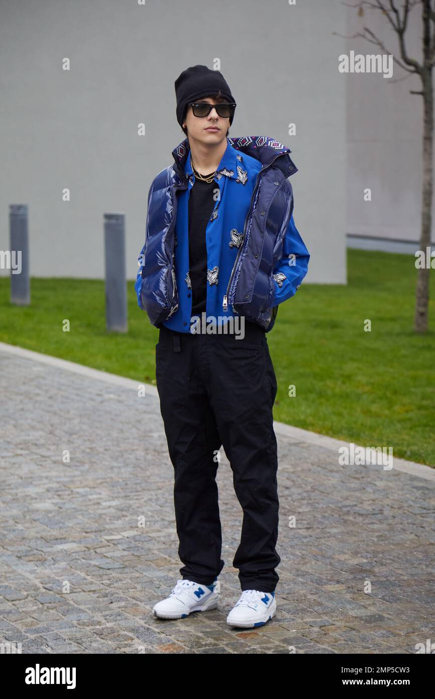 MILAN, ITALY - JANUARY 15, 2023: Man with blue padded jacket and black trousers before Etro fashion show, Milan Fashion Week street style Stock Photo