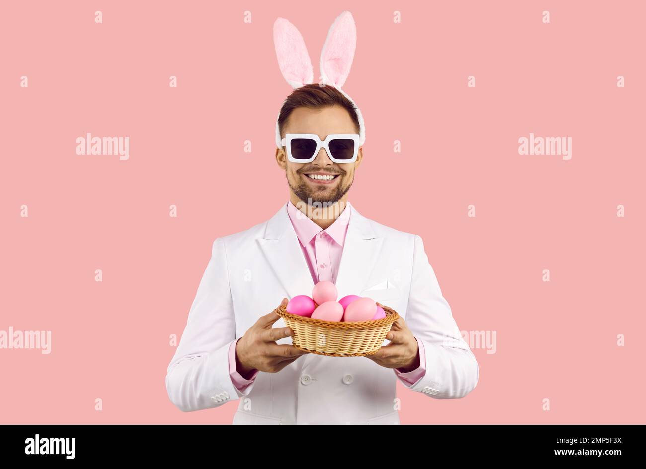 Smiling man with bunny ears hold basket with eggs Stock Photo