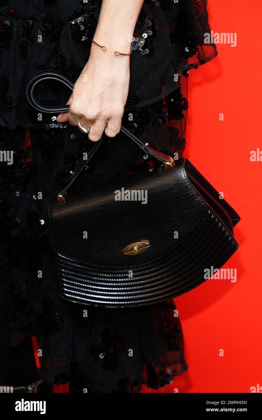 Actress Chloe Sevigny holds a handbag as she poses at the premiere of