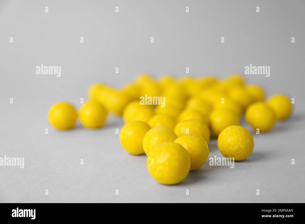 Delicious lemon chewing gums on light grey background, closeup Stock