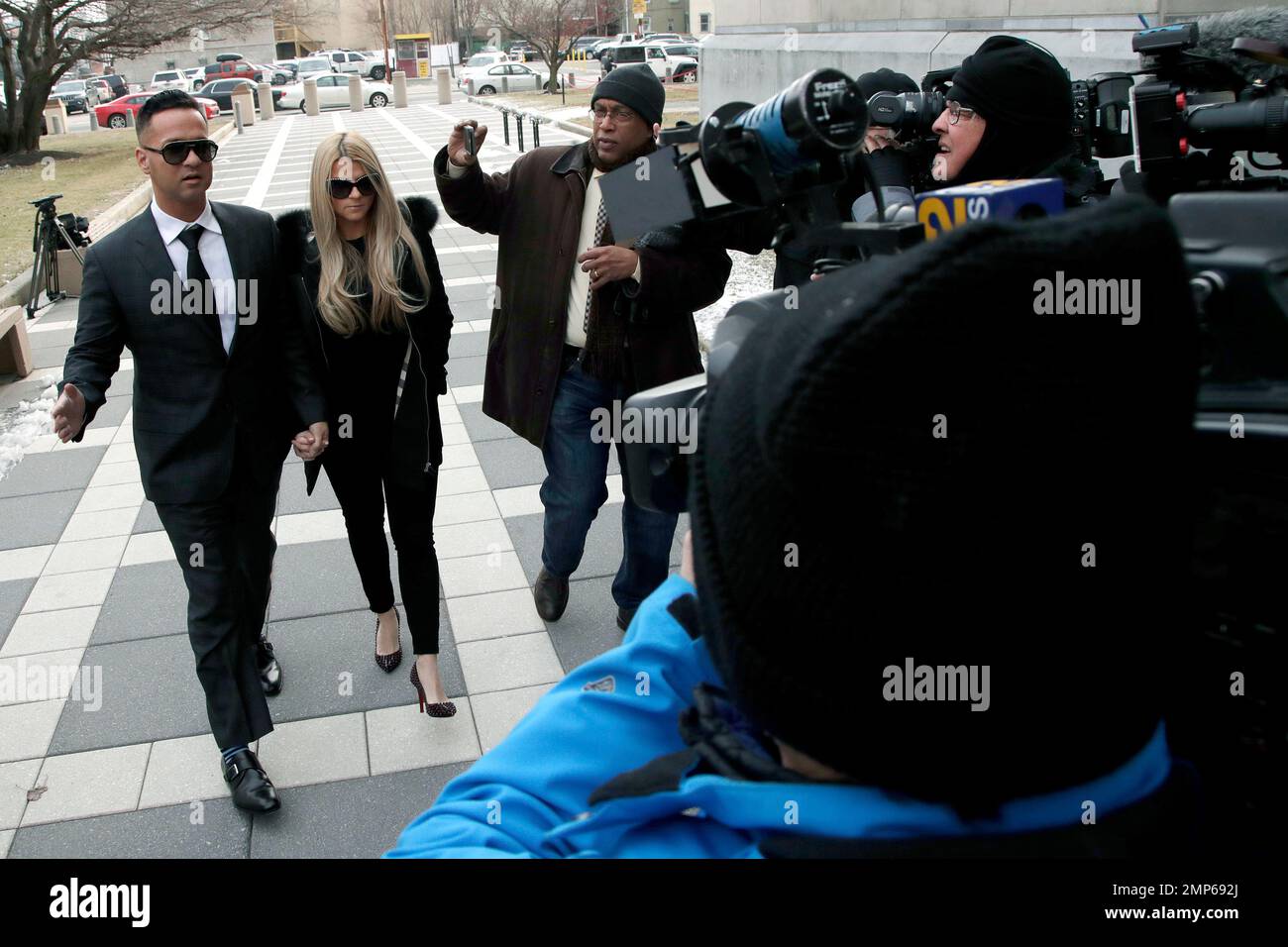 Michael "The Situation" Sorrentino, left, one of the former stars of the  "Jersey Shore" reality TV show walks with his fiancee Lauren Pesce as  reporters swarm them while arriving at the Martin