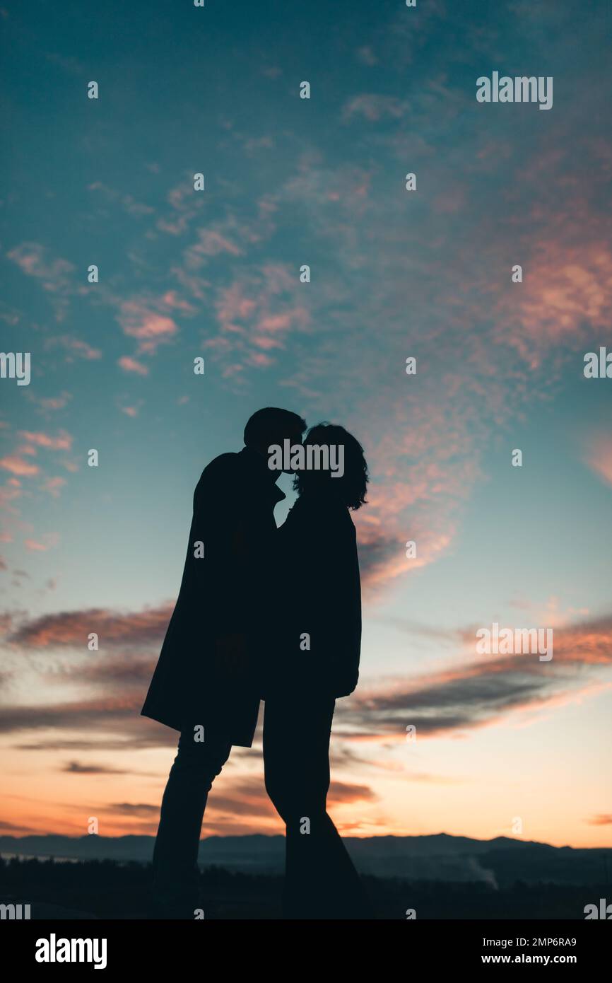 Silhouette of Couple kissing at sunset Stock Photo - Alamy