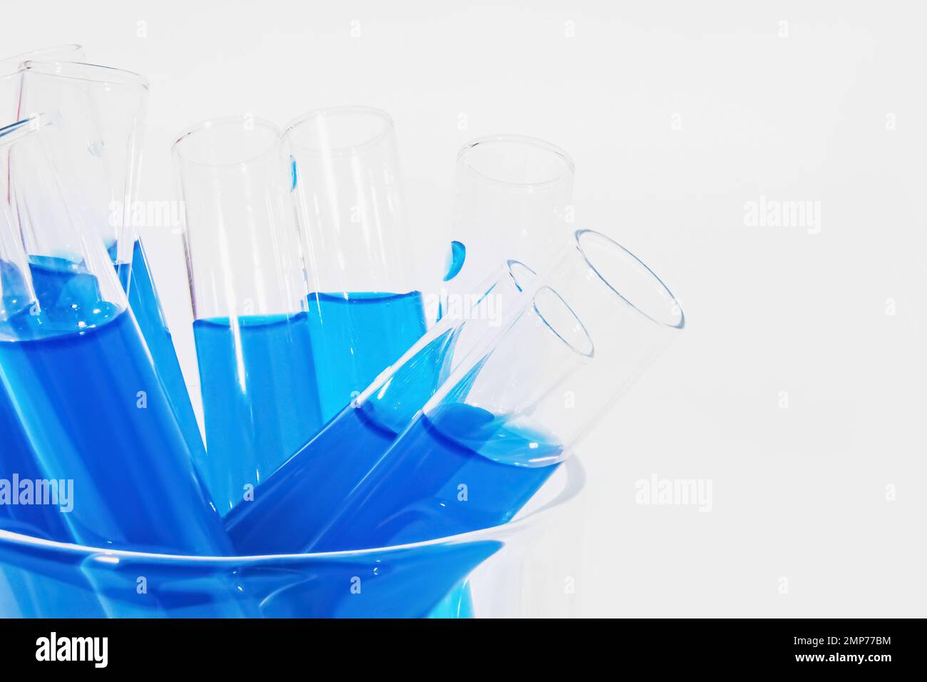 Transparent glass test tubes on a white background, blue liquid ...