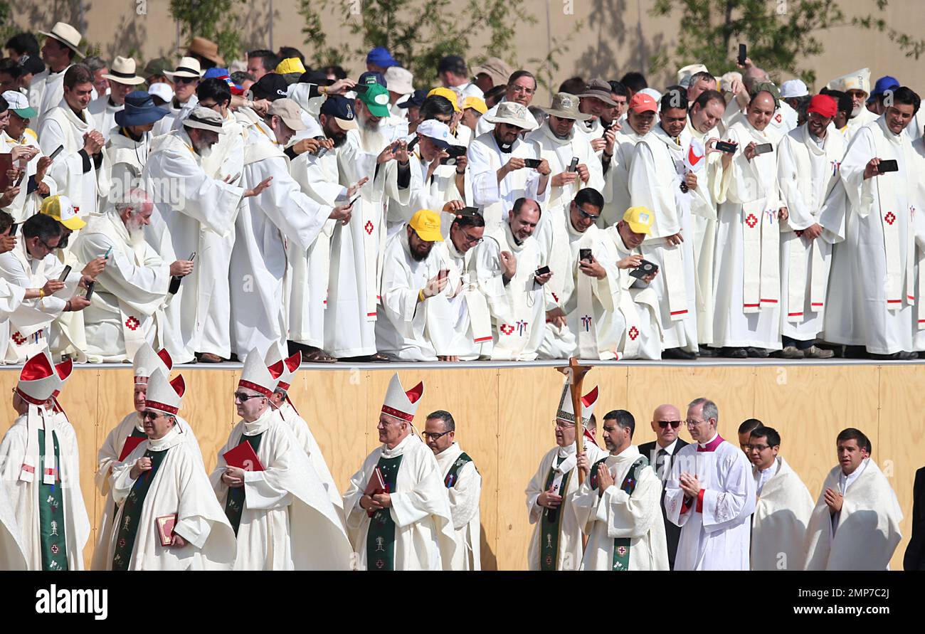 Clergy take pictures of Pope Francis walking toward the altar ...