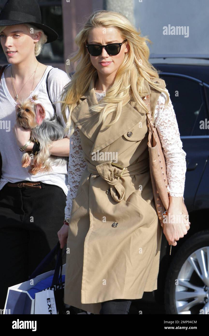 Showing off her long blonde locks, actress Amber Heard looks lovely in a tan sleeveless coat and lace top paired with black pants as she leaves a hair salon in Los Angeles, CA. 24th February 2012. Stock Photo