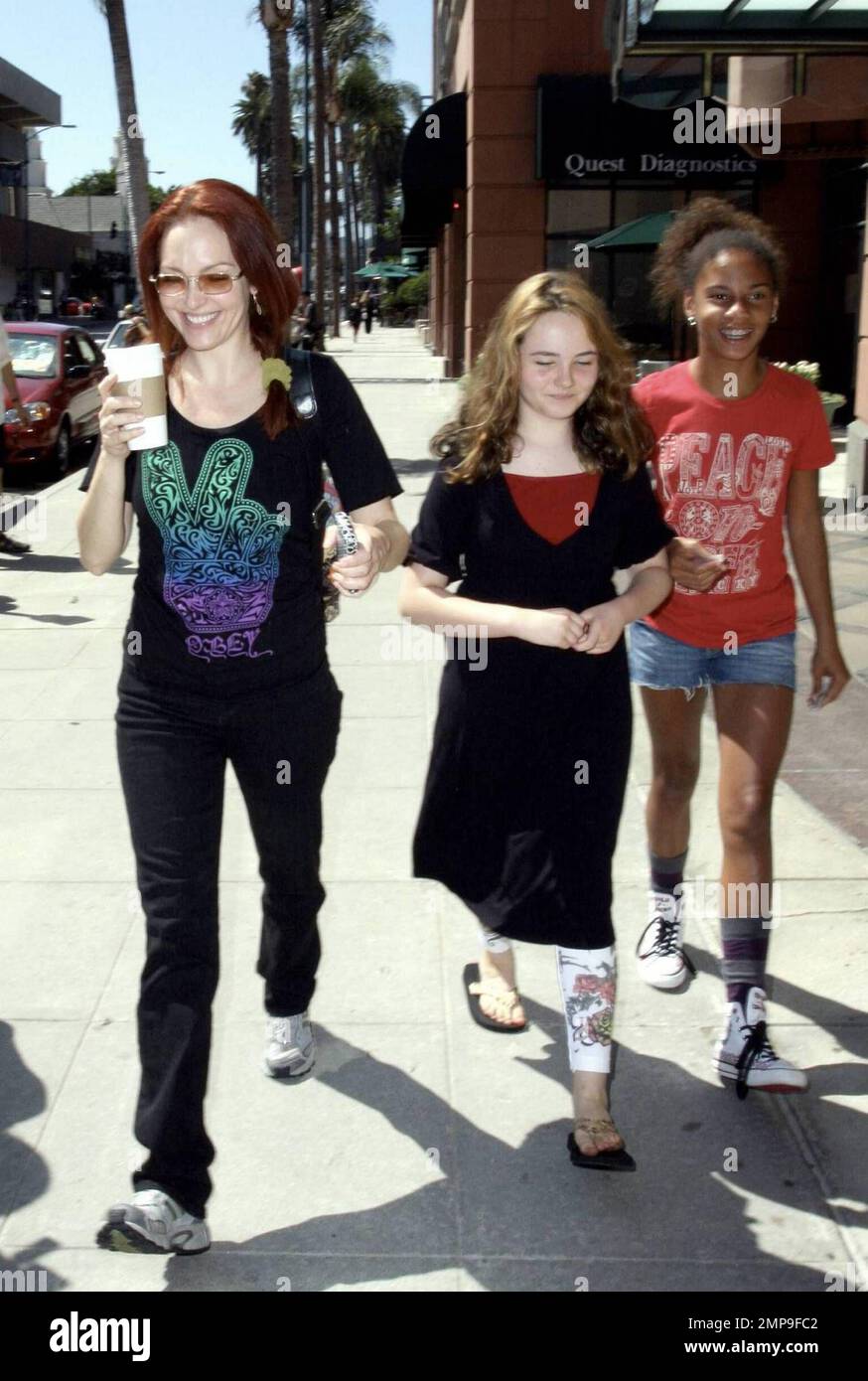 Actress Amy Yasbeck wears a top with a large, colorful peace sign on it as she strolls in Beverly Hills with two young friends after stopping in for some coffee. Yasbeck, best known for her roles on the sitcom 'Wings' and in the movie 'The Mask,' has also made appearances on 'That's So Raven,' 'Life on a Stick' and 'Just Shoot Me.' Beverly Hills, CA. 7/16/09. Stock Photo