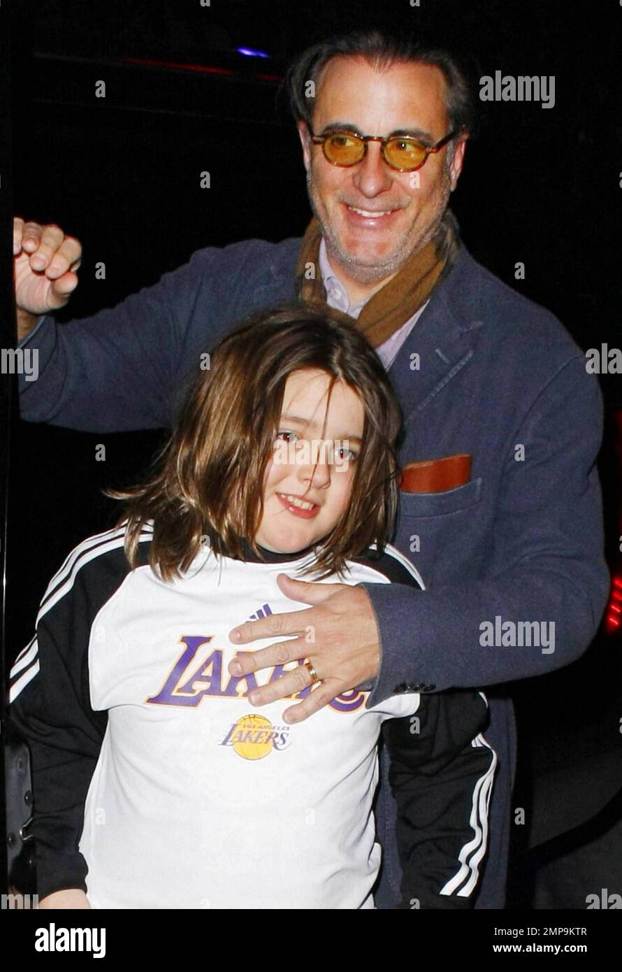 Andy Gardia and son Andres, 8, arrive in an SUV at the Staples Center to watch the LA Lakers vs. Houston Rockets basketball game.  Andy protectively held Andres, who wore a Lakers shirt, close as they smiled and made their way inside where they watched the Lakers beat the Rockets 114-106.   Los Angeles, CA. 02/01/11. Stock Photo