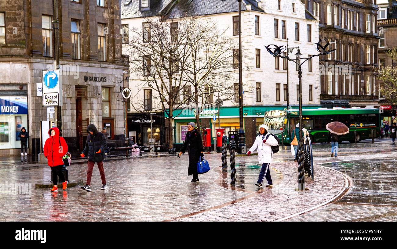 Dundee, Tayside, Scotland, UK. 31st Jan, 2023. UK Weather. Temperatures in Northeast Scotland dropped to 5°C due to a combination of unexpected torrential rainfall and cold winter sunshine. Local residents in Dundee city centre are caught off guard by sudden and heavy scattered showers while going about their daily business. Credit: Dundee Photographics/Alamy Live News Stock Photo