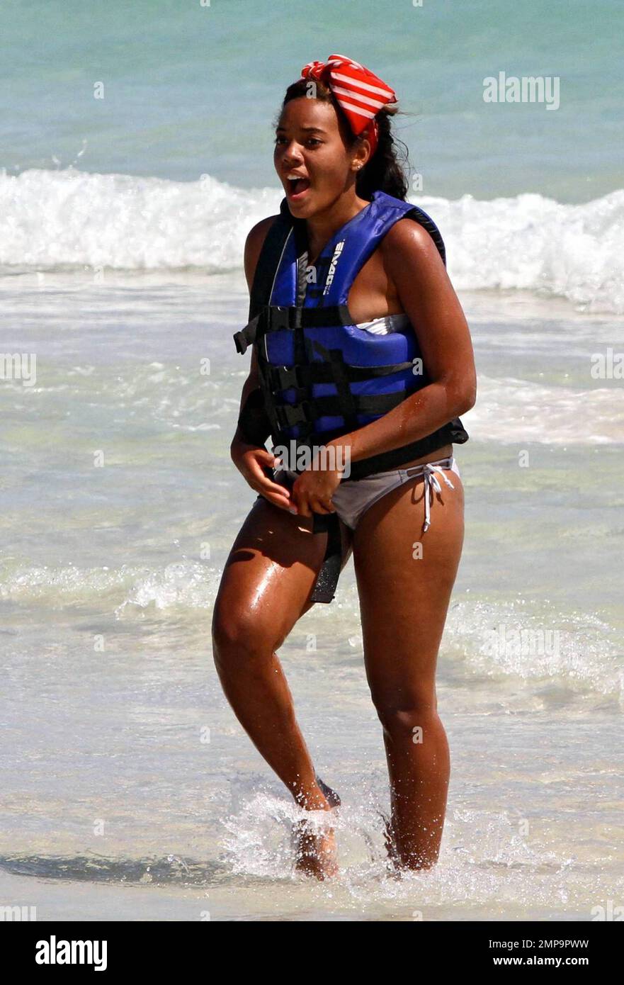 American socialite and entrepreneur, Angela Simmons, best known as the daughter of Run-D.M.C.'s Rev Run and neice of hip-hop legend Russell Simmons, wears a silver bikini paired with a floppy red scarf on her head as she spends an afternoon with a friend soaking up the sun on trendy South Beach. Angela looked like she had a blast while jet skiing and donned a zebra-print cover-up as she strolled with her friend on the sand. Miami Beach, FL.  3/1/11. Stock Photo