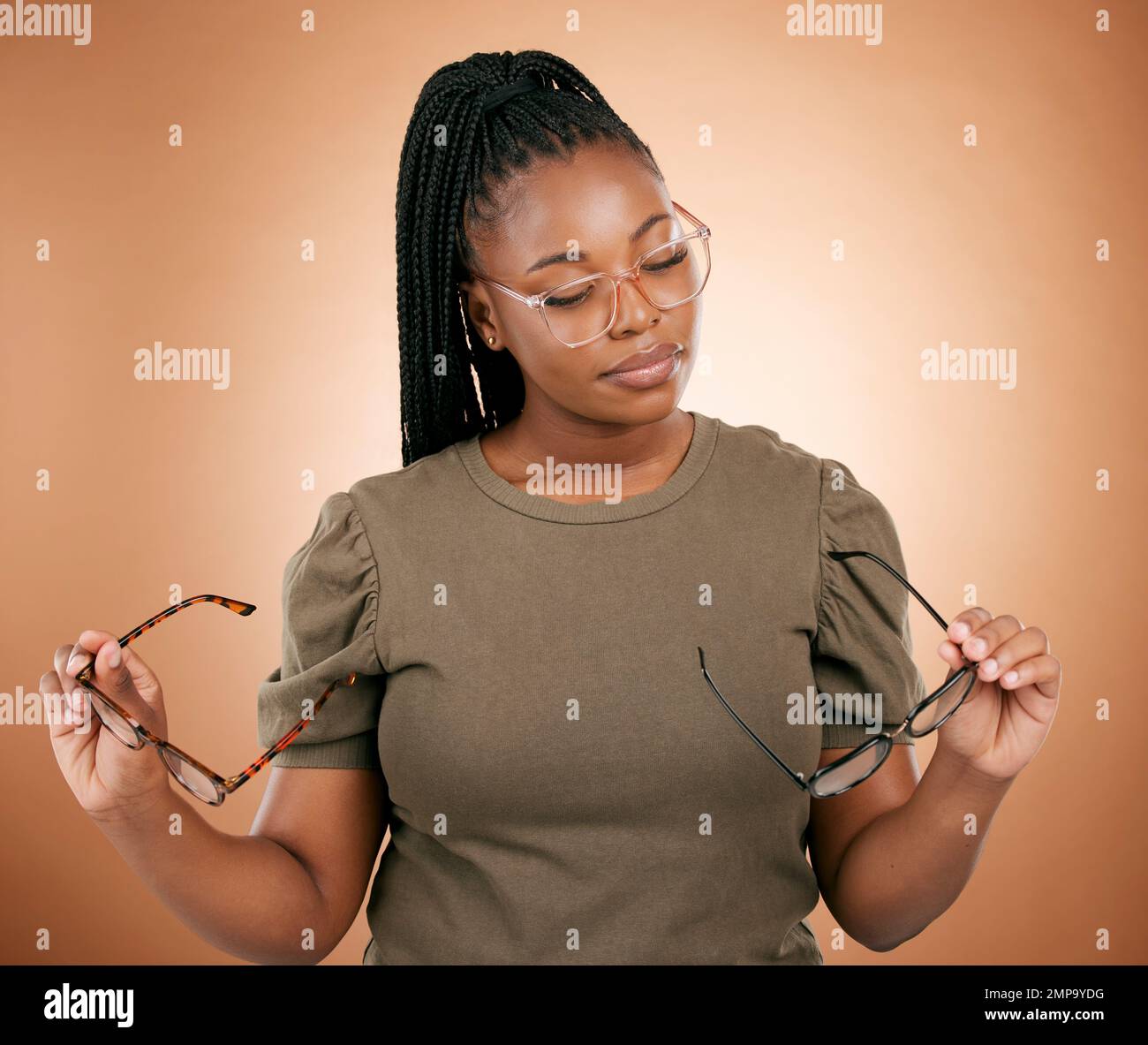 Woman, studio and choose glasses for eyecare, health and vision for thinking, beauty and decision. African model, choice and fashion spectacles for Stock Photo