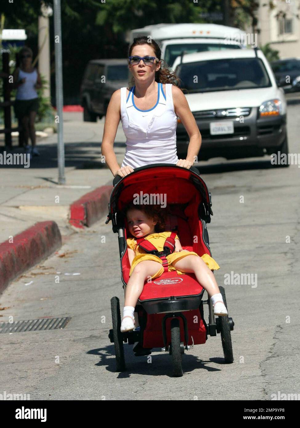 British actress and 'Pushing Daisies' star Anna Friel jogs around her neighborhood with her daughter Gracie and her mom [check].  Anna, who appears to be in great shape, ran for over a mile while pushing Gracie's stroller and barely breaking a sweat. Her pace was so fast that several of the photographers trying to shoot her could barely keep up with her. It seems that the sunny Southern California lifestyle really suits her. Los Angeles, CA. 10/9/08. Stock Photo