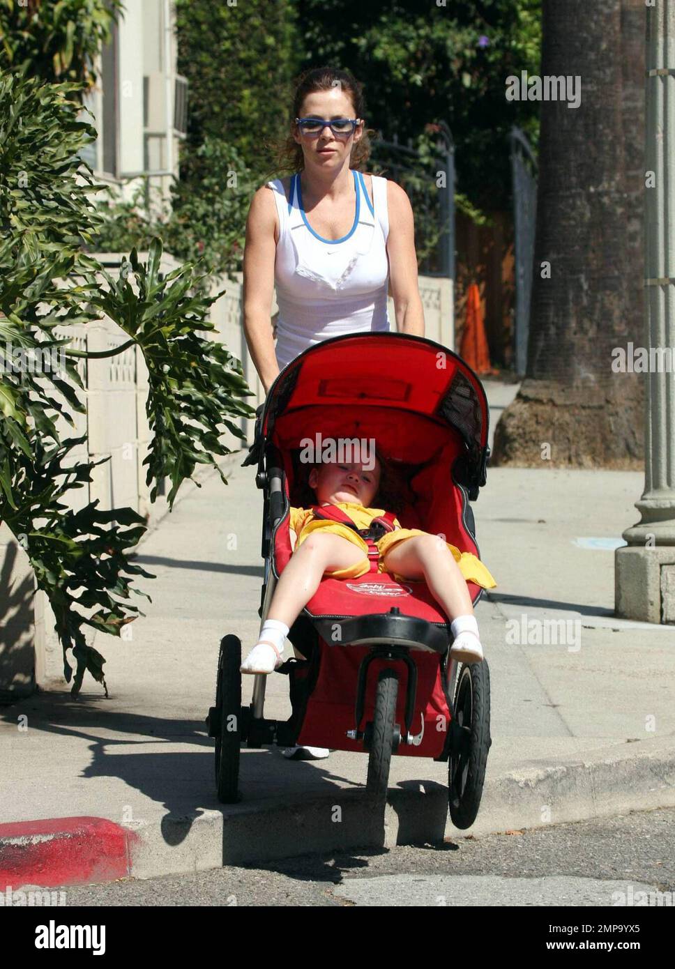 British actress and 'Pushing Daisies' star Anna Friel jogs around her neighborhood with her daughter Gracie and her mom [check].  Anna, who appears to be in great shape, ran for over a mile while pushing Gracie's stroller and barely breaking a sweat. Her pace was so fast that several of the photographers trying to shoot her could barely keep up with her. It seems that the sunny Southern California lifestyle really suits her. Los Angeles, CA. 10/9/08. Stock Photo