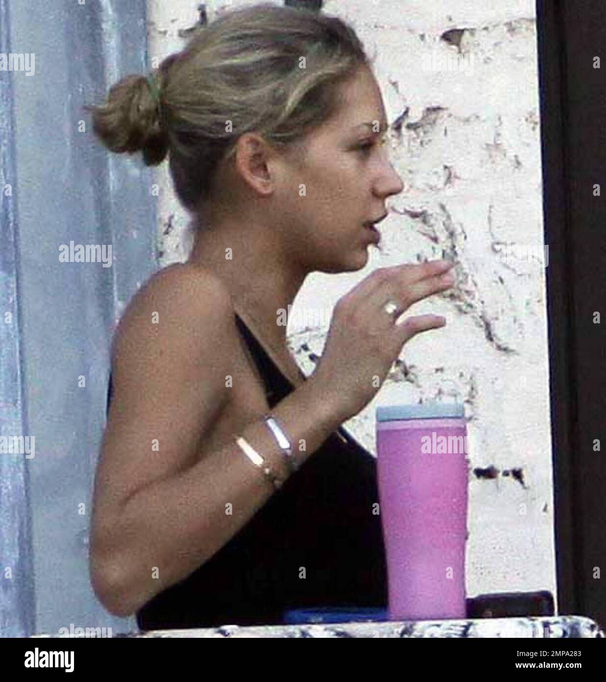 EXCLUSIVE!! Despite recent rumors of pregnancy, Anna Kournikova was spotted  on the balcony of her beleaguered home smoking a cigarette and looking at  her figure in the reflection of a glass door