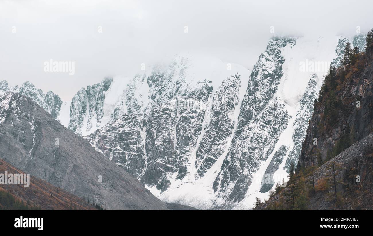 Mountains with snow and glaciers with peaks in fog and clouds in the ...