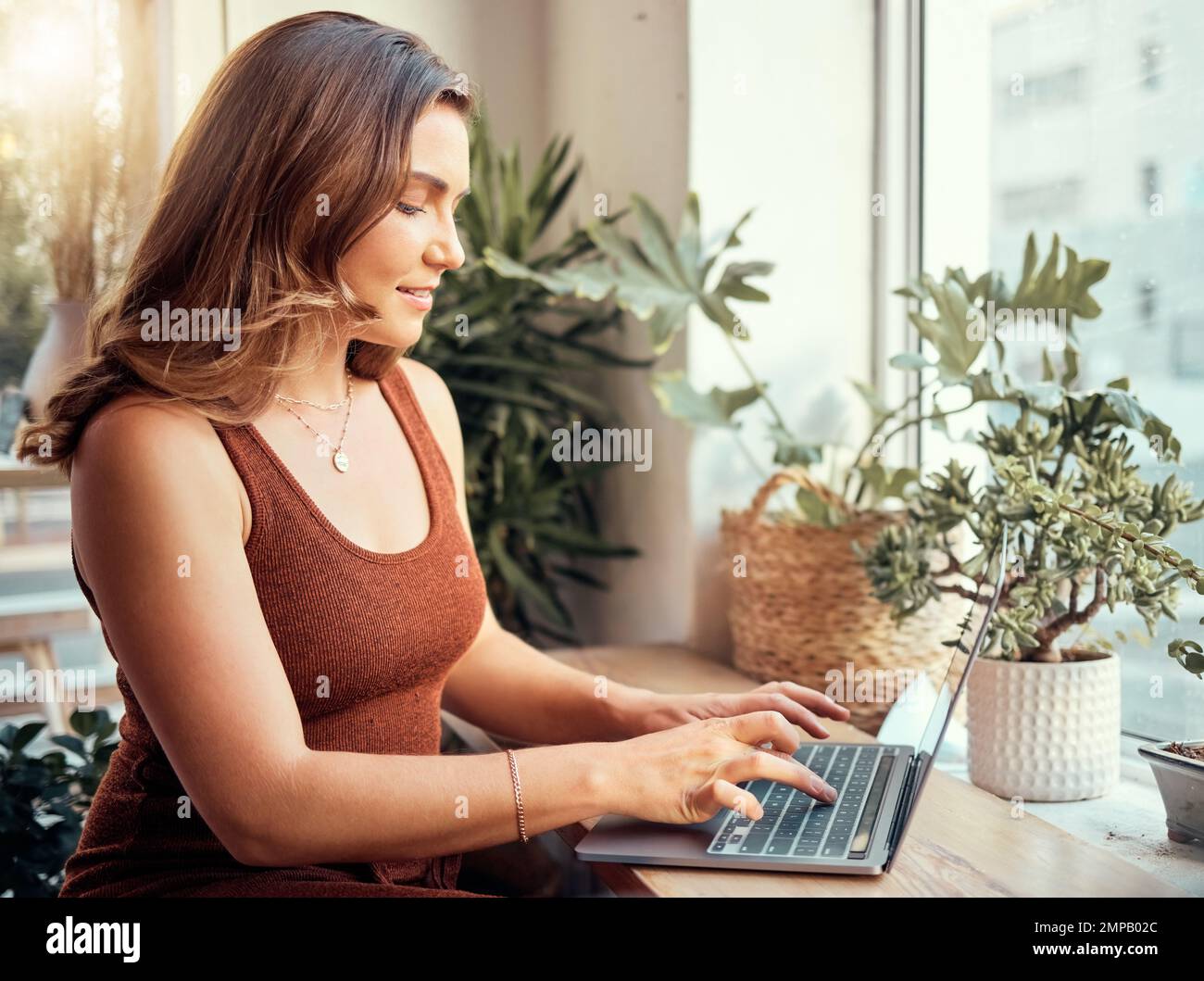 Happy woman, laptop or typing in coffee shop, cafe or restaurant on internet blogging, internet research or learning course. Smile, entrepreneur or Stock Photo