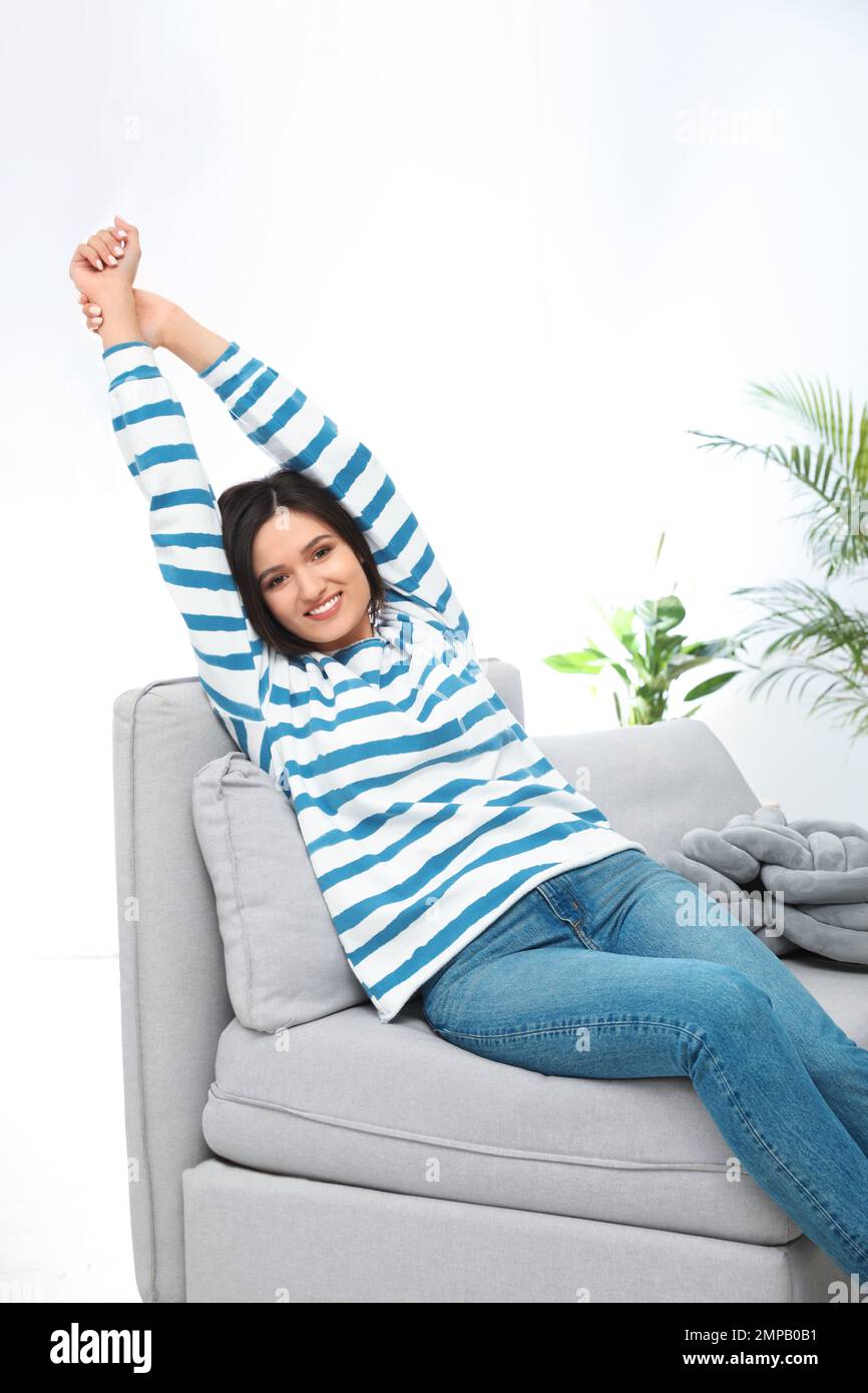 Young woman relaxing on couch at home Stock Photo - Alamy
