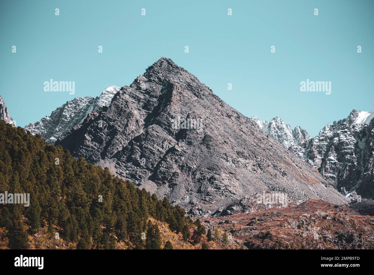 The top of a rocky mountain in the form of a pyramid against the sky ...