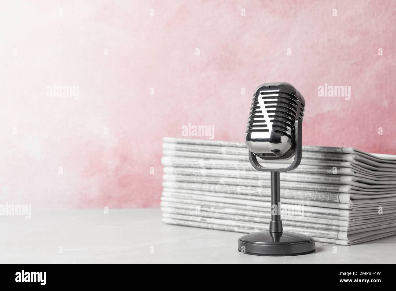 Newspapers and vintage microphone on table, space for text. Journalist's work Stock Photo