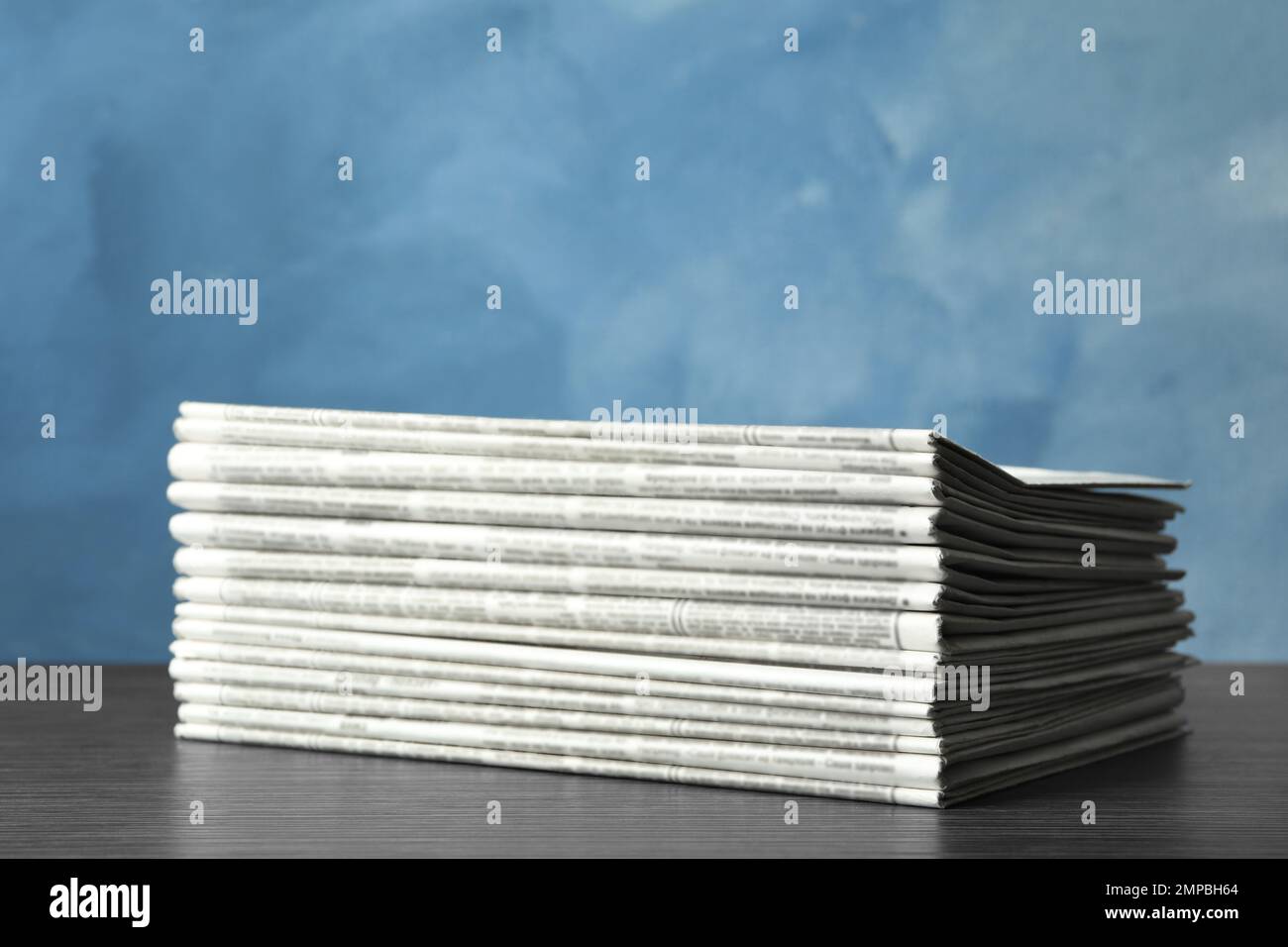 Stack of newspapers on blue background. Journalist's work Stock Photo