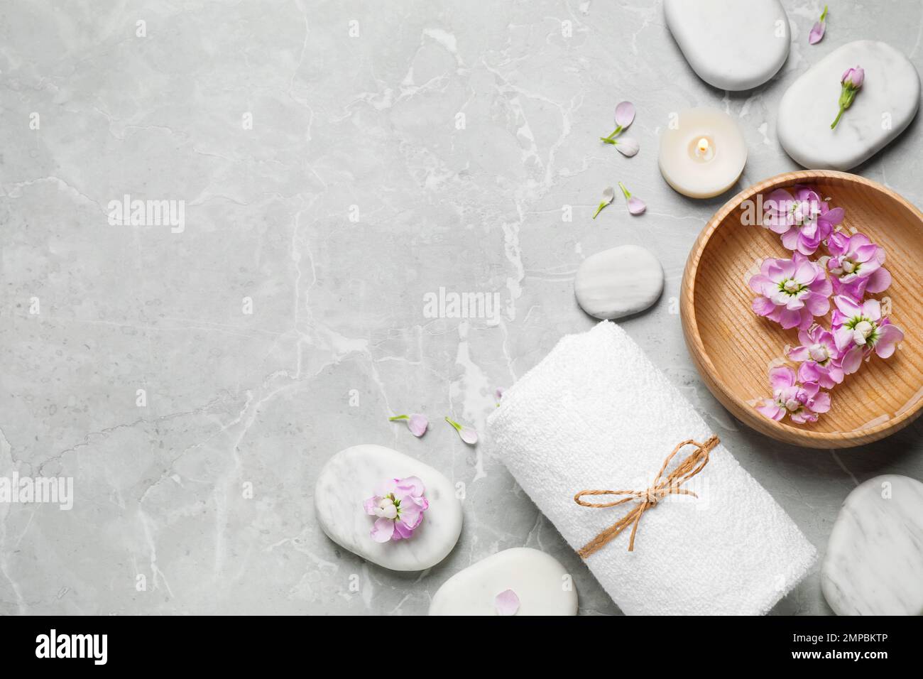 Flat lay composition with spa stones on light grey marble table, space ...